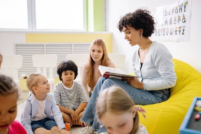 School children listening to a story read by a teacher